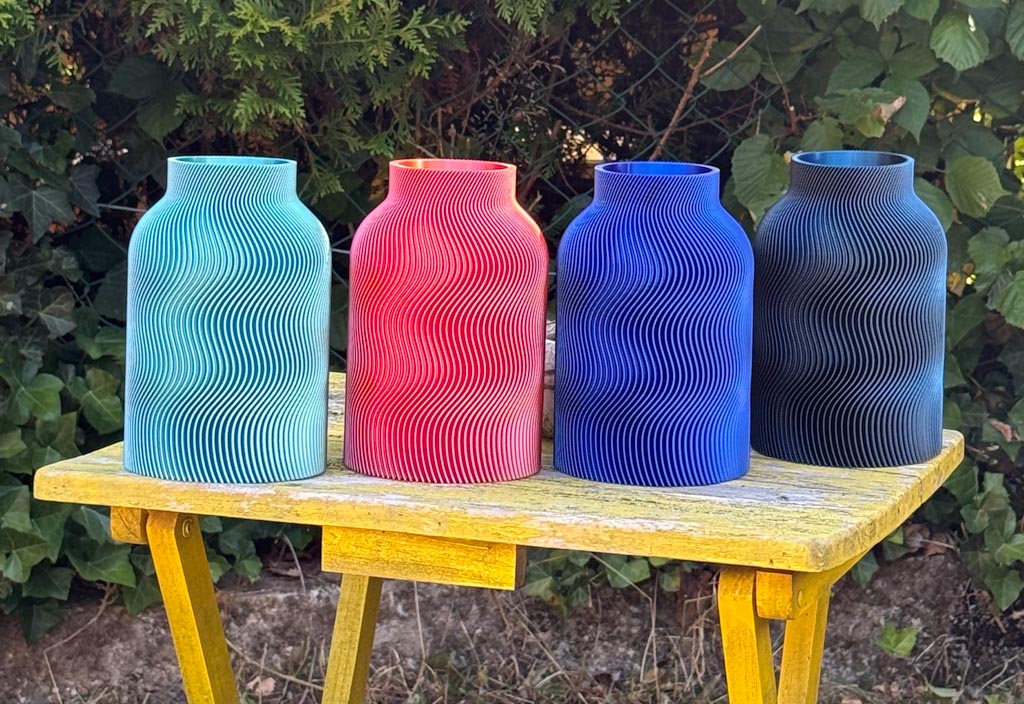 Farbenfrohe 3D-Druck-Vasen von TAO Dekor – türkis, koralle und blau auf einem gelben Tisch