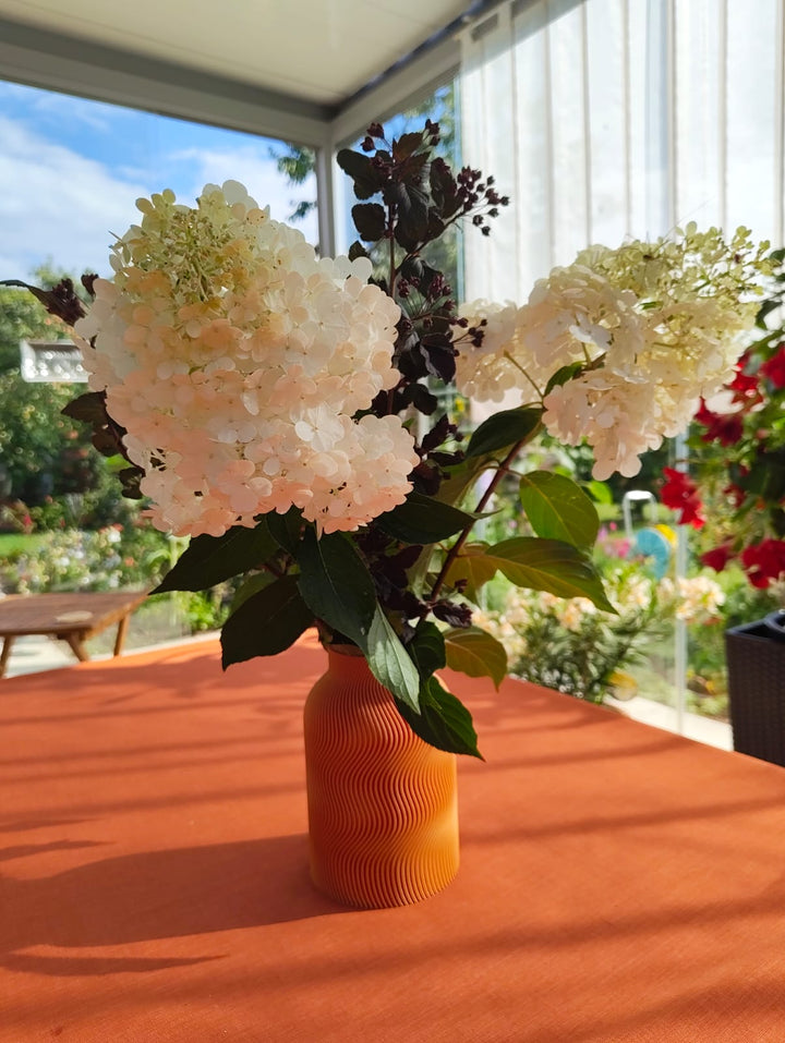 Luna Vase in Orange mit Hortensien im Wintergarten – Kundenfoto